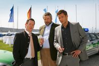 Die Rosenheim-Cops – Im Yachthafen stellen die Cops Stadler (Dieter Fischer, M.) und Hansen (Igor Jeftic, r.) Bürgermeister Schretzmayer (Jürgen Tonkel, l.) zur Rede.