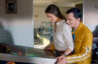 Die Farbe des Windes – Lionel (Anthony Jeanne) zeigt Luna (Laura Berlin) den altmodischen Flipper in der Dorfkneipe.