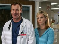 Scrubs - Die Anfänger – Cox' Schwester Paige (Cheryl Hines, r.), die durch und durch gläubig ist, ist in der Stadt. Als bei ihrem Besuch im Krankenhaus bei einem Patienten keine Behandlung mehr anschlägt, biete sie den Angehörigen an, mit ihnen zu beten. Das bringt Cox (John C. McGinley, l.) allerdings auf die Palme ...