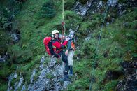 Die Bergretter – Der Bergretter Tobias (Markus Brandl, l.) bringt den bewusstlosen und verletzten Mann (Sebastian Hofmüller, r.) auf dem schnellsten Weg ins Krankenhaus.