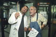 Löwenzahn Classics – Mit Hilfe der gefundenen Feder erkennt der Tierarzt (Aykut Kayacik, l.), dass der "Kobold" im Garten von Peter Lustig (r.) ein Uhu sein muss.