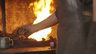 Spiel mit dem Feuer - Die Ofenbauer – Der Schmied nimmt sein Werkzeug in die Hand und im Hintergrund brennt das Feuer im Ofen