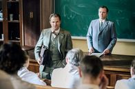Charité – Parteisekretär Lehmann (Nicholas Reinke, r.) fordert von der Ärzteschaft der Charité ein schriftliches Bekenntnis zum Mauerbau. Doch dann wird er von Prof. Dr. Otto Prokop (Philipp Hochmair, r.) unterbrochen, der überraschend aus Wien zurückkommt.