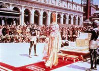Cleopatra – Imperien treffen aufeinander, Ägypten in Rom: Cleopatra (Elizabeth Taylor) ist in Rom angekommen und hat sich von ihrem Thron erhoben, um Caesar und Marcus Antonius zu begrüßen.