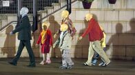 Doctor Who – Drei Erwachsene Schaufensterpuppen und Drei junge Schaufensterpuppen auf der Straße unterwegs.