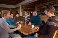Der Bergdoktor – Krisensitzung bei den Grubers: Wie kann man Gregor aufhalten? Für eine schnelle Lösung müssen Susanne (Natalie O'Hara, l.), Lilli (Ronja Forcher, 2.v.l.), Lisbeth (Monika Baumgartner, 3.v.l.), Anne (Ines Lutz, 3.v.r.), Martin (Hans Sigl, 2.v.r.) und Hans (Heiko Ruprecht, r.) an einem Strang ziehen.