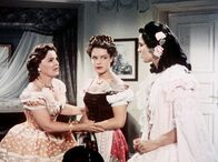Sissi – Ludovika (Magda Schneider, li.) bereitet ihre älteste Tochter Helene (Uta Franz, re.), genannt Nene, auf das Treffen mit dem österreichischen Kaiser vor. Die stürmische, junge Sissi (Romy Schneider) stört da nur.