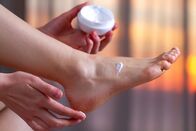 MIRI - proud to be – Junge Frau, die sich um ihre Füße kümmert und eine feuchtigkeitsspendende Creme aufträgt. Fuß- und Hautpflege. Schutz und Hydratation der Fersen