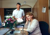 Um Himmels Willen – Kleiner Flirt am Arbeitsplatz: Sekretärin Marianne Laban (Andrea Wildner, r.) und Archivar Anton Michels (Hansi Kraus, l.).