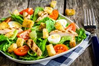 Rachs 5€-Küche – Caesar salad with croutons, quail eggs, cherry tomatoes and grilled chicken on rustic table