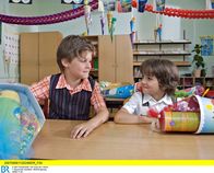 In aller Freundschaft – Die Eltern überlassen den Kindern die Plätze - die beiden Freunde Jonas Heilmann (Anthony Petrifke, rechts) und Bastian Marquardt (Johann Lukas Sickert) sitzen bei der Einschulung in der ersten Reihe.