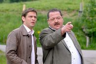 Die Rosenheim-Cops – Stinksauer zeigt Korbinian Hofer (Joseph Hannesschläger, r.) seinem Kollegen Christian Lind (Tom Mikulla), was sich auf dem Hof des Paulus abspielt.