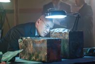 Mayday - Alarm im Cockpit – Der leitende Ermittler (gespielt von Von Flores) inspiziert die Black Boxes, die aus den Trümmern von China-Airlines-Flug 140 geborgen wurden.