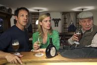 Mord mit Aussicht – Sophie Haas (Caroline Peters, M.) muss ihrem Vater zuliebe in Hengasch bleiben und trifft sich mit Andreas Zielonka (Max Gertsch, l.) und dessen Vater Hans (Michael Hanemann, r.) im Gasthof. Doch die Runde wird durch eine Neuigkeit aufgeschreckt.