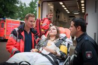 Notruf Hafenkante – Auch Tina (Emilia von Heiseler, M.) ist zusammengebrochen und wird von Dr. Haase (Fabian Harloff, l.) versorgt. Doch ob es sich um eine Vergiftung handelt, kann er Tarik (Serhat Cokgezen, r.) noch nicht sagen.