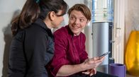 Sturm der Liebe – Theo (Lukas Leibe, r. mit Yeliz Simsek, l.) freut sich, als seine App von einem Onlinedienst im Sortiment aufgenommen wird.
