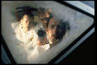 Apollo 13 – Der Mond war zu weit weg. Die Männer von Apollo 13, Fred Haise (Bill Paxton, l.), Jack Swigert (Kevin Bacon, M.) und Jim Lovell (Tom Hanks, r.), werfen vor dem Versuch, heil auf die Erde zurück zu kommen, einen letzten Blick auf das vergebliche Ziel ihrer Mission.