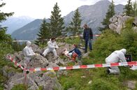 Watzmann ermittelt – Während die Spurensicherung (Komparsen) noch arbeitet, erläutert Rechtsmediziner Dr. Philipp Hartmann (Jakob Graf, 2.v.l..) den Kommissaren Sophia Strasser (Katharina Leonore Goebel, 3.v.r.) und Jerry Paulsen (Peter Marton, 2.v.r.) die Todesumstände von Biologin Valerie Lemke.