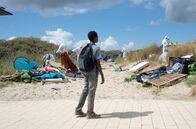 Eden – Auf dem Weg zum Strand beobachtet Amare (Joshua Edoze), wie ein illegales Camp von den Behörden weggeräumt wird.
