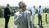 Die Chefin – Harald Bruns (Steffen Wink, 2.v.l.) nimmt während seines Business-Meetings ein wichtiges Telefonat entgegen.