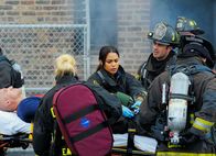 Chicago Fire – Versorgen ihren verletzten Kollegen: Mo Gallini als Jose Vargas, Lauren German als Shay, Monica Raymund als Gabrielle Dawson, Taylor Kinney als Kelly Severide
