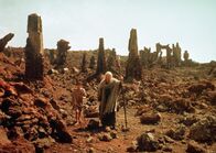 Die Bibel – Abraham (George C. Scott, r. ) mit seinem Sohn Isaak (Alberto Lucantoni) in den Ruinen der von Gott zerstörten Stadt Sodom.