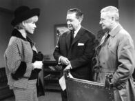 Das Phantom von Soho – Während seiner Ermittlung macht Chefinspektor Patton (Dieter Borsche, r.) Bekanntschaft mit Clarinda Smith (Barbara Rütting, l.), der reizenden Verlobten von Sir Phillip (Hans Söhnker, M.).