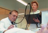 In aller Freundschaft – Prof. Simoni (Dieter Bellmann) bekommt während einer Untersuchung von Oberschwester Ingrid (Jutta Kammann) die Nachricht von der Einlieferung Reimers.