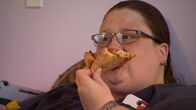 Mein Leben mit 300 kg – Kandi eats a slice of pizza.