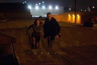 In Time - Deine Zeit läuft ab – Immer wieder gelingt es Will (Justin Timberlake, r.) und Sylvia (Amanda Seyfried, l.), Zeitkapseln, in denen die Zeit aufbewahrt wird, zu erbeuten und an die Armen weiterzugeben. Das unmenschliche System droht zu kollabieren, und die Mächtigen setzen alles daran, die beiden außer Gefecht zu setzen ...