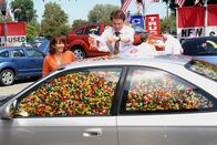 The Middle – Um ihren Job zu retten, kommt Frankie (Patricia Heaton, l.) eine tolle Marketing-Idee. Sie füllt gemeinsam mit Bob (Chris Kattan, r.) einen der angebotenen Gebrauchtwagen mit Jelly Beans. In einer großen Verlosung sollen die Teilnehmer der Verlosung raten, wie viele Jelly Beans in dem Auto sind ...