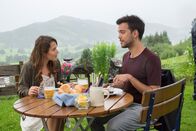 Frühling – Filipa (Cristina do Rego) und Miguel (Yannik Raiss) genießen ein gemeinsames Mittagessen und amüsieren sich über den verrückten Mark.