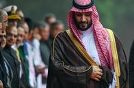 Der Prinz von Saudi-Arabien – Mohammed Bin Salman läuft mit saudischer Kopfbedeckung an einer Reihe von Menschen vorbei.