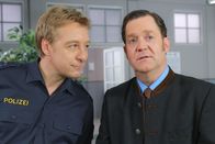 Die Rosenheim-Cops – Der Gantinger Bürgermeister Karl Schretzmayer (Jürgen Tonkel, r.) bittet Polizist Michi Mohr (Max Müller, l.) um Hilfe.
