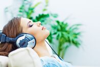aktiv und gesund – Sleeping woman at home with headphones, listening music.