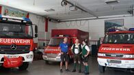 Hoagascht – Patrick Eisl (rechts), HFM Ludwig Fischer (links) und ABI Werner Fischer (mitte) stehe in der Fahrzeughalle der FF Altaussee und unterhalten sich während ServusTV’s „Hoagascht – Sonderlöscheinsatz am Kiritog, in Altaussee, Österreich am 31. August 2024.