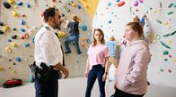WaPo Elbe – Angie Thoma (Sofie Eifertinger, h.M.) beobachtet, wie Kommissar Fares ( Adnan Maral, li.) mit Nele (Amelie Gerdes, re.) spricht.