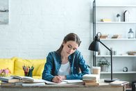 English bite-size – Teenage girl writing and studying at desk at home