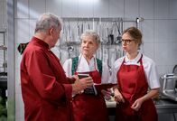 Sturm der Liebe – Vor Hildegard (Antje Hagen, M.) erfährt Josie (Lena Conzendorf, r.) von André (Joachim Lätsch, l.) mit welchen Methoden die "Schoko-Götter" gegen sie arbeiten. ARD/Christof Arnold