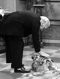 Dinner for One oder Der neunzigste Geburtstag – Diener James (Freddie Frinton) streichelt im volltrunkenen Zustand den Tigerkopf.