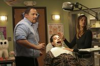 Monk – Um herauszufinden, was Adrian Monk (Toni Shalhoub, M.) über den Mordfall bereits weiß, wird er qualvoll vom Zahnarzt (Jon Favreau, l.) und seiner Assistentin Terri (Brooke Langton, r.) auf den Zahnarztstuhl gefesselt.