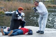 SOKO Kitzbühel – Ein toter Rollstuhlfahrer (Komparse, liegend) wurde aus dem Schwarzsee geborgen. Gerichtsmedizinerin Dr. Löcker (Veronika Polly, l.) und ein Spurensicherer (Komparse, r.) machen ihre Arbeit.