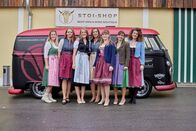Landfrauenküche – Die Landfrauen in Dirndl vor STOI-Shop und VW Bus.