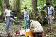 Deadly Tropics – Das Ermittlerteam Mélissa Sainte-Rose (Sonia Rolland, l.), Gaëlle Crivelli (Beatrice de la Boulaye, M. hinten) und Aurélien Charlery (Julien Beramis, r. ) muss sich um einen neuen Fall kümmern: die Rentnerin Eva Courson (Dominique Douces, M.) wurde erschlagen im Wald aufgefunden. Sie trägt einen Schlüssel bei sich. Pathologe Philippe Dorian (Valentin Papoudof, vorne) hilft den Kommissaren.