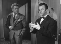 Edgar Wallace: Das indische Tuch – Der Anwalt Frank Tanner (Heinz Drache, links) versucht auch dem seltsamen Butler Bonwit (Eddy Arendt) Hinweise zu entlocken, die auf die Spur des Mörders führen könnten.