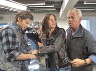 In aller Freundschaft – Brigitte Mohn (Patrizia Moresco, Mitte), die Chefin des Motorradclubs, kühlt die abgetrennten Gliedmaßen von Maik Schröder (Igor Jeftic, links) geistesgegenwärtig. Auch Otto Stein (Rolf Becker) ist zu Hilfe geeilt.