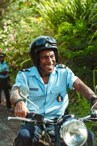 Death in Paradise – Dwayne Myers (Danny John-Jules) darf für den Job auf seinem Motorrad fahren, so schnell es geht. Eine Aufgabe nach seinem Geschmack.
