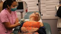 Dr. Pimple Popper – Dr. Sandra Lee performs surgery to remove Juliet's lumps while she holds a mirror.