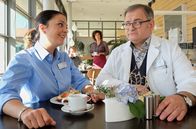 In aller Freundschaft – Durch einen alleinstehenden, älteren Patienten ist Hans-Peter Brenner (Michael Trischan, re.) klar geworden, dass er sich mit dem Alleinsein eingerichtet hat. Doch das ist nicht das, was er will. Seine Freundin Arzu Ritter (Arzu Bazman, li.) rät ihm, unter Menschen zu gehen, etwas zu unternehmen ... nur so kann er auch Jemanden kennenlernen. Linda Schneider (Isabel Varell, hi. mi.), die Hans-Peter Avancen macht, bekommt Bruchteile des Gespräches mit.