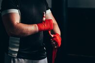 Mixed Martial Arts – Boxer putting on red straps and getting ready to fight